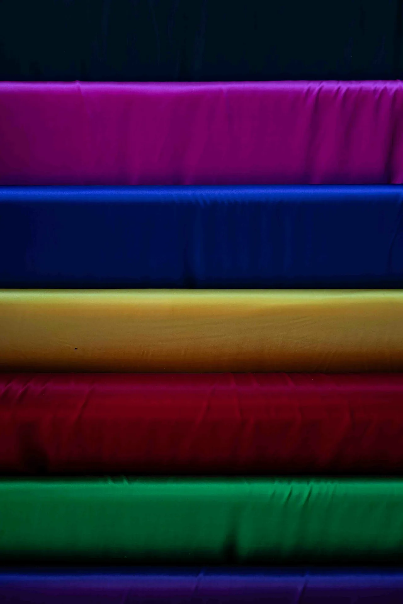 Stacked rolls of colourful fabric